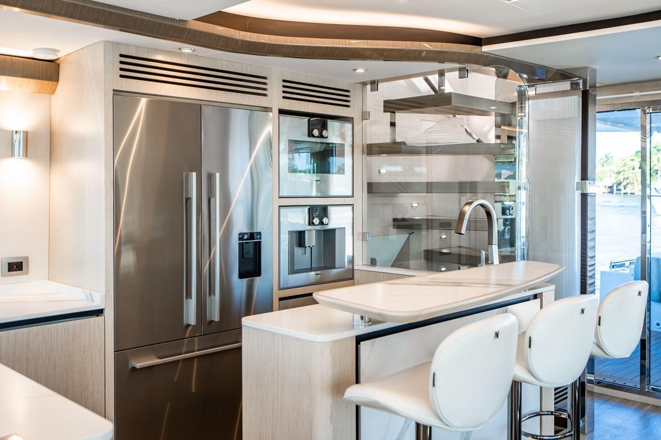 a kitchen with a refrigerator and a sink aboard PLANE TO SEA Yacht for Sale