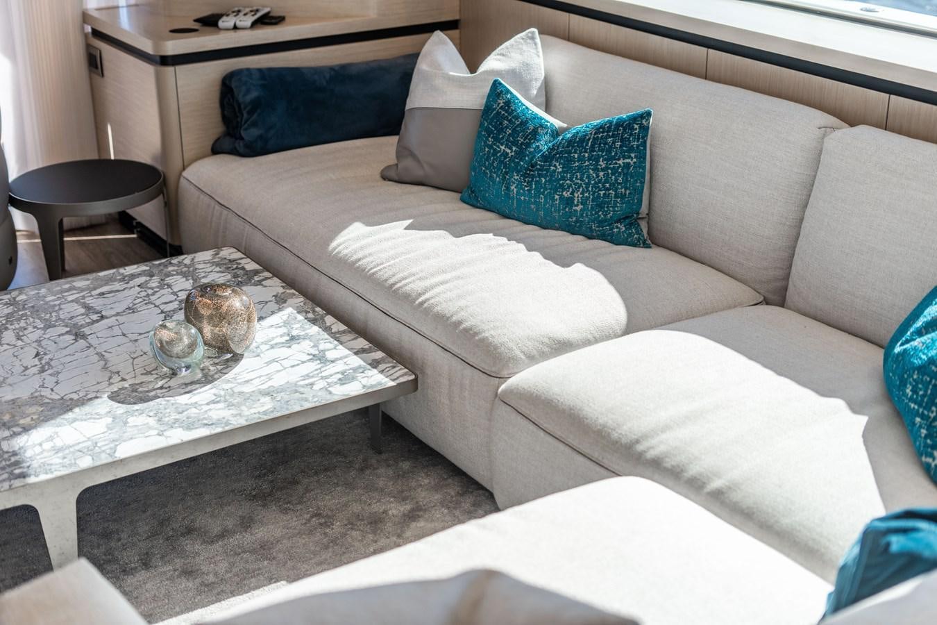 a white couch with blue pillows aboard PLANE TO SEA Yacht for Sale