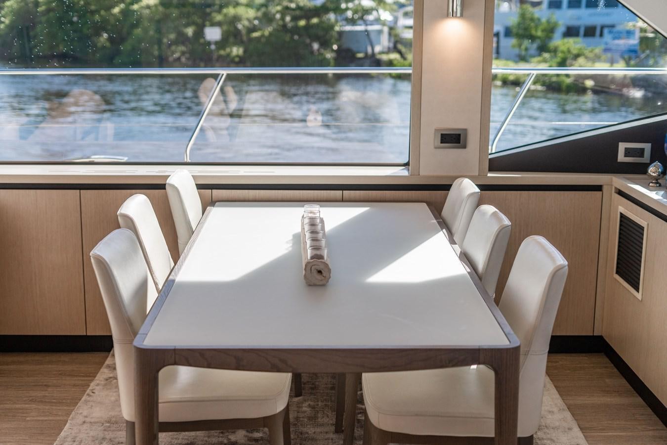 a table with chairs and a window aboard PLANE TO SEA Yacht for Sale