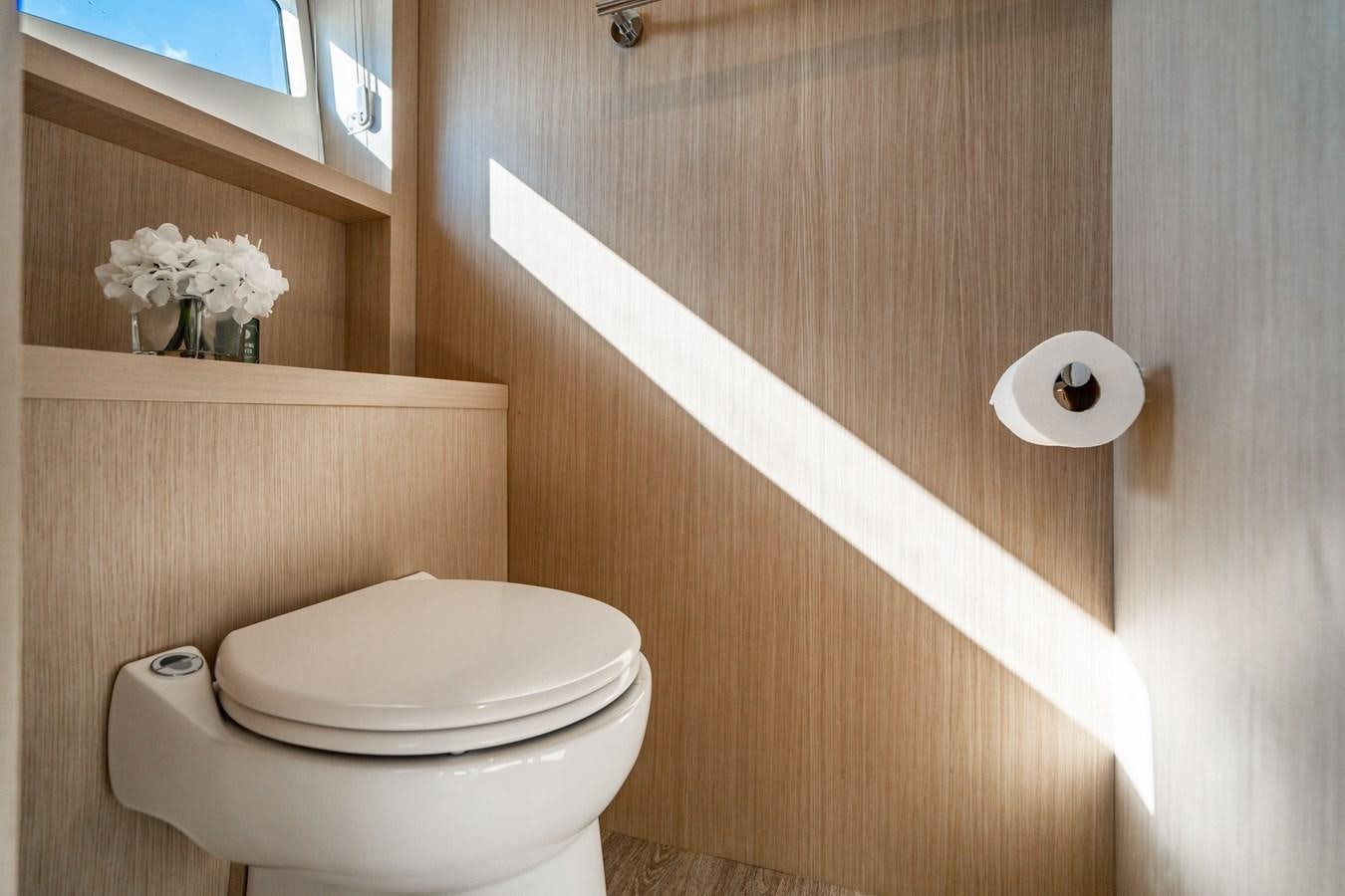 a toilet with a wooden wall aboard PLANE TO SEA Yacht for Sale