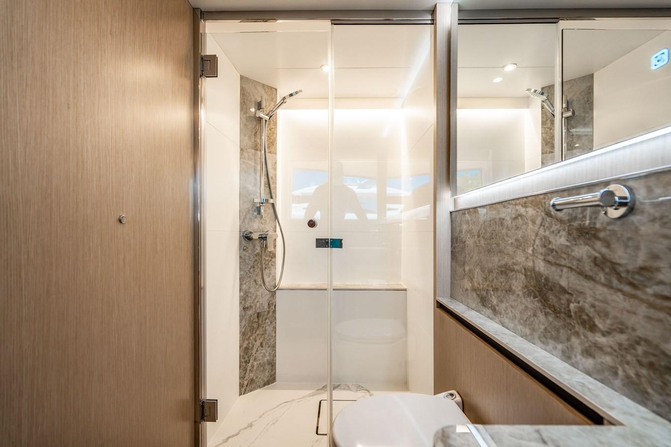a bathroom with a glass shower aboard PLANE TO SEA Yacht for Sale