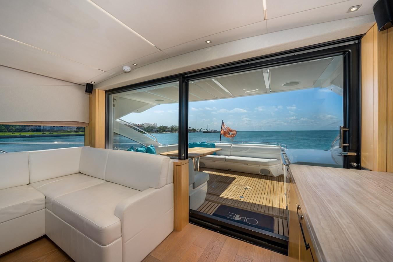 a room with a couch and a table and a large window aboard SUNSEEKER PREDATOR 68 Yacht for Sale