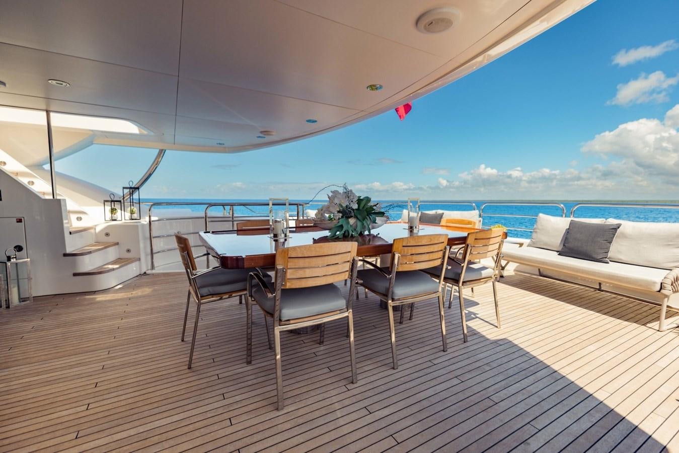 a table and chairs on a deck aboard TAYRONA Yacht for Sale