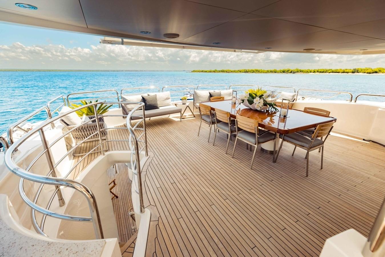 a patio with tables and chairs on it next to a body of water aboard TAYRONA Yacht for Sale
