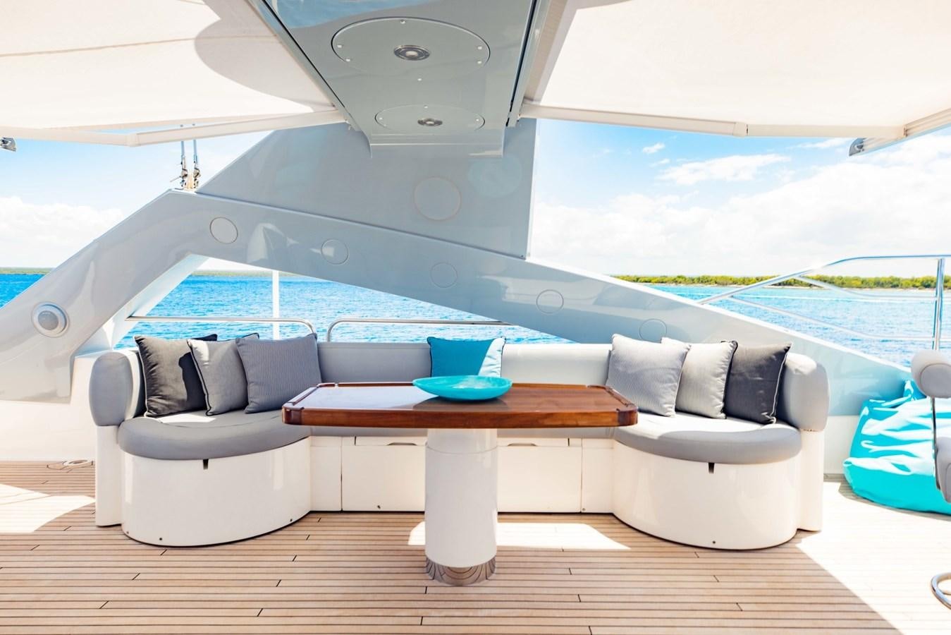 a white couch with a table and a coffee table on a wood floor aboard TAYRONA Yacht for Sale