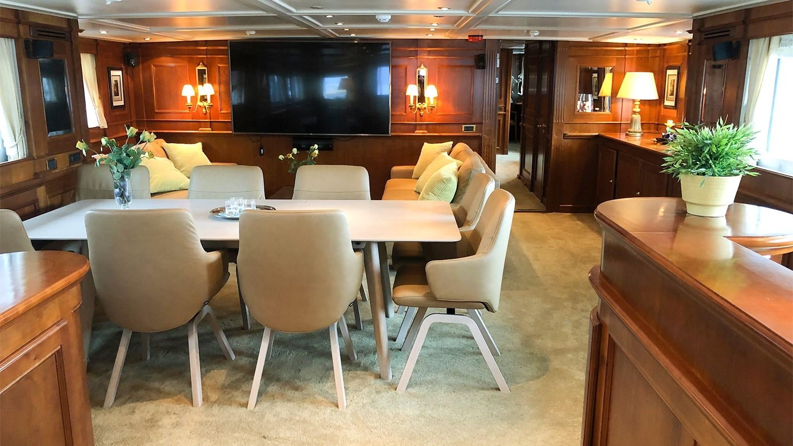 a room with a table chairs and a tv aboard CHANTAL Yacht for Sale