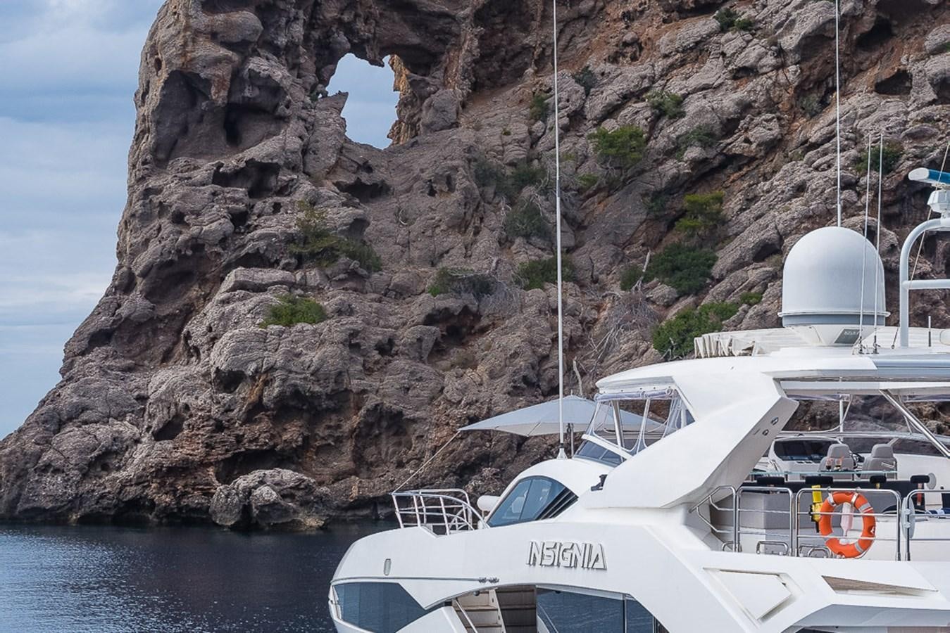 a boat parked on the side of a rocky cliff aboard INSIGNIA Yacht for Sale