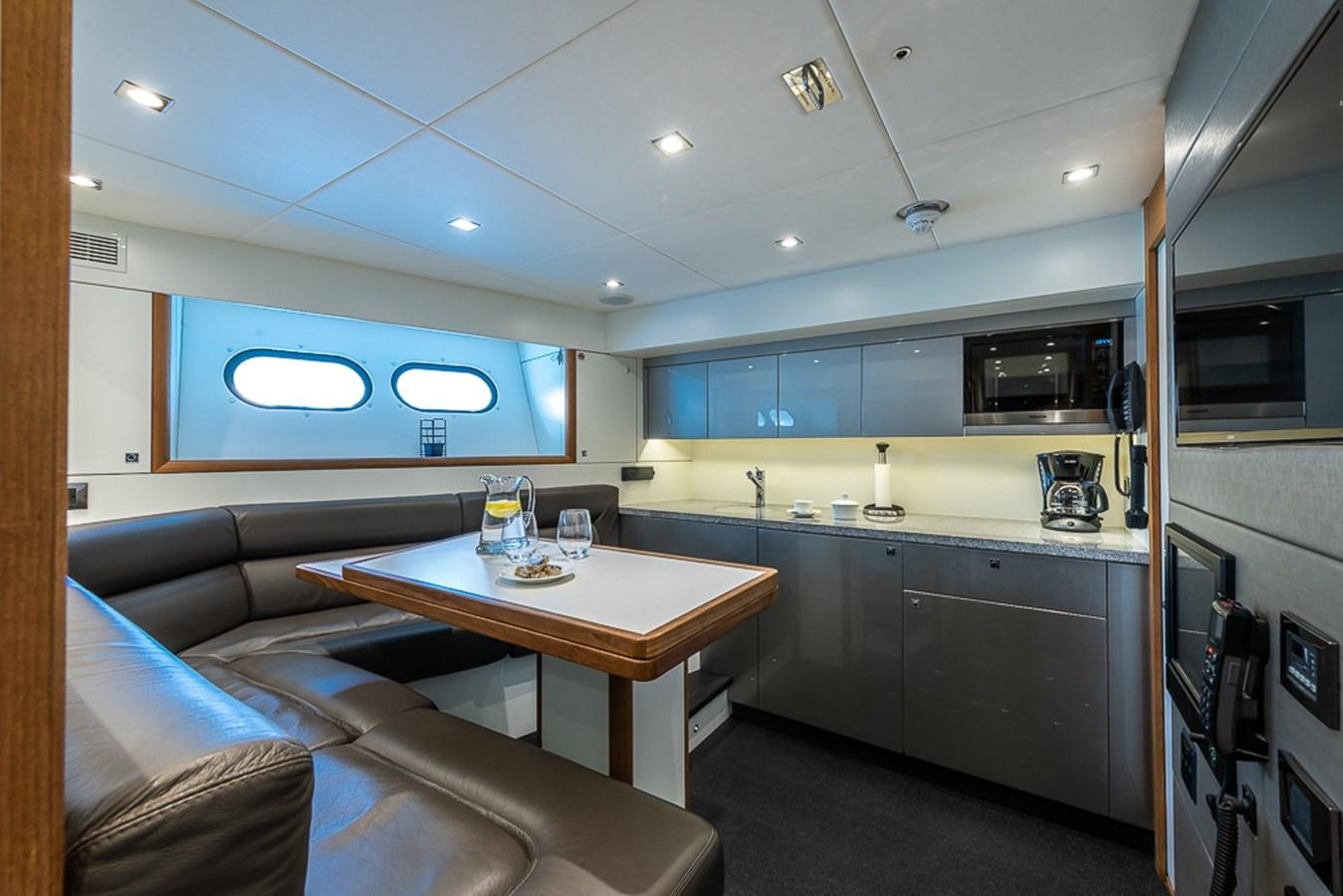 a kitchen with a table and chairs aboard INSIGNIA Yacht for Sale