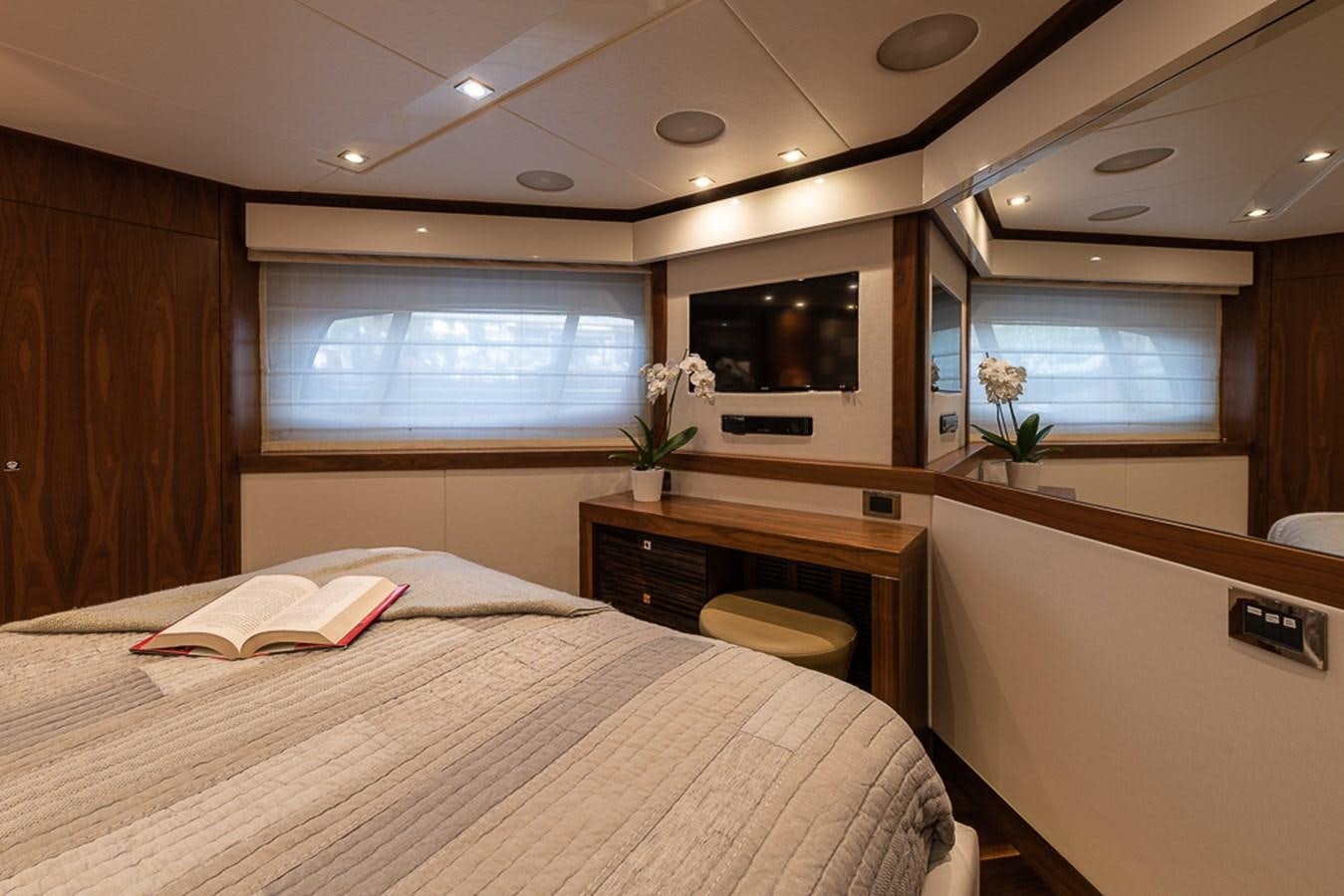 a bedroom with a bed and a tv on the wall aboard INSIGNIA Yacht for Sale