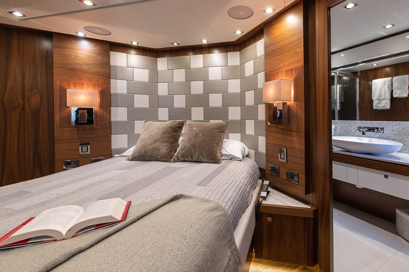 a hotel room with a bed and a mirror aboard INSIGNIA Yacht for Sale