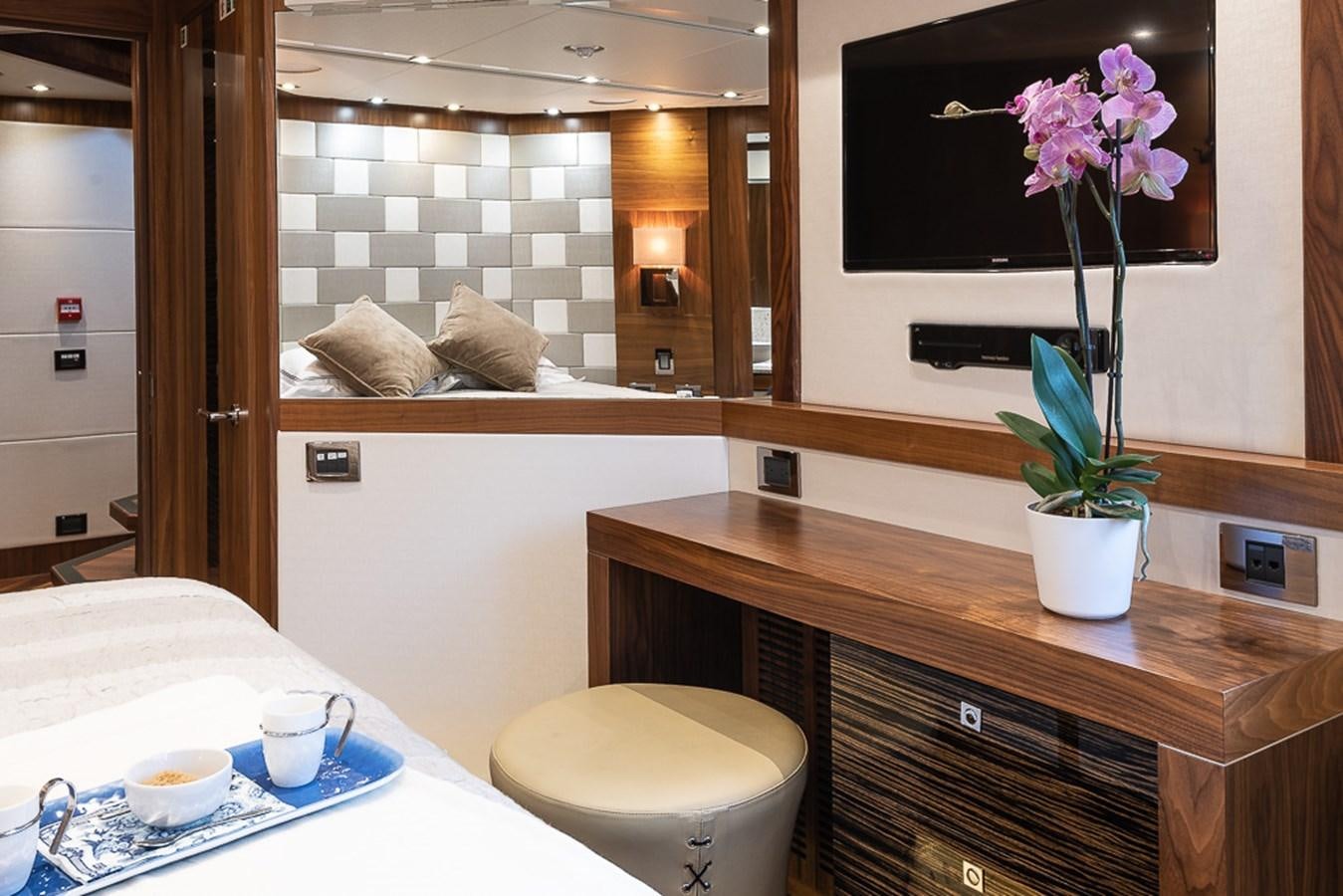 a room with a tv and a table with a plant in it aboard INSIGNIA Yacht for Sale