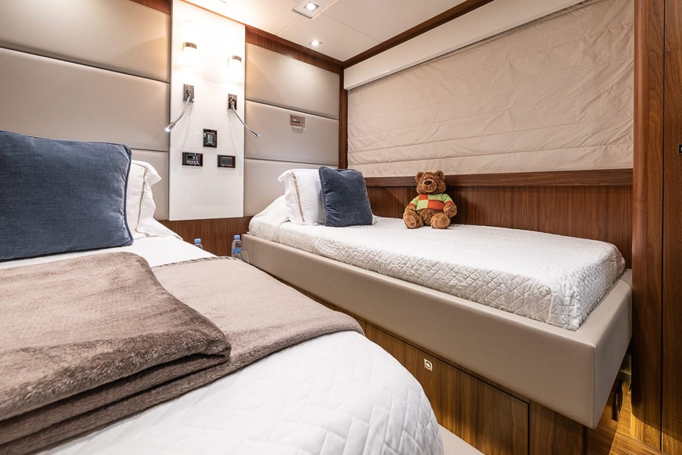a small stuffed bear sits on a bed aboard INSIGNIA Yacht for Sale