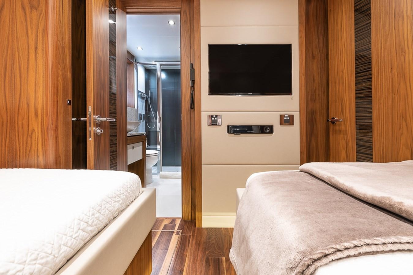 a bedroom with a bed and a television aboard INSIGNIA Yacht for Sale