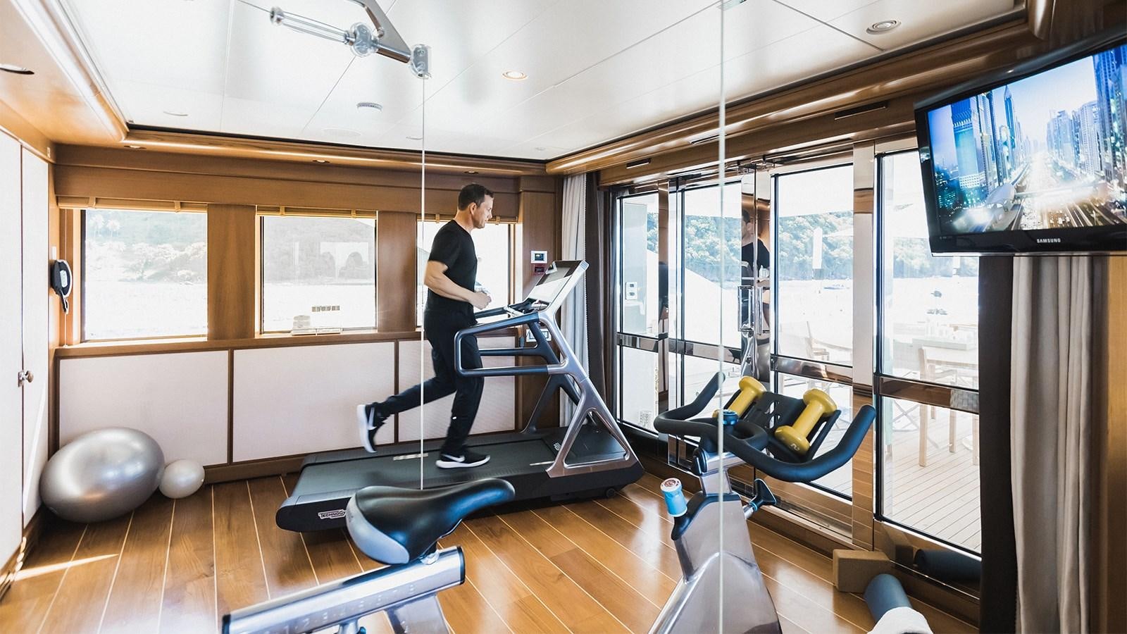 a person working out in a gym aboard CLELIA III Yacht for Charter