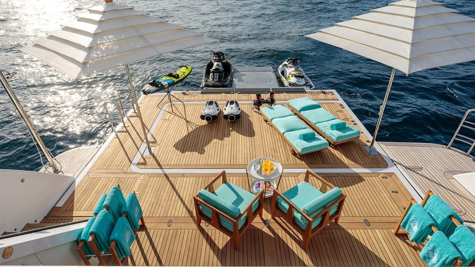 a deck with a boat and chairs on it aboard CLELIA III Yacht for Charter