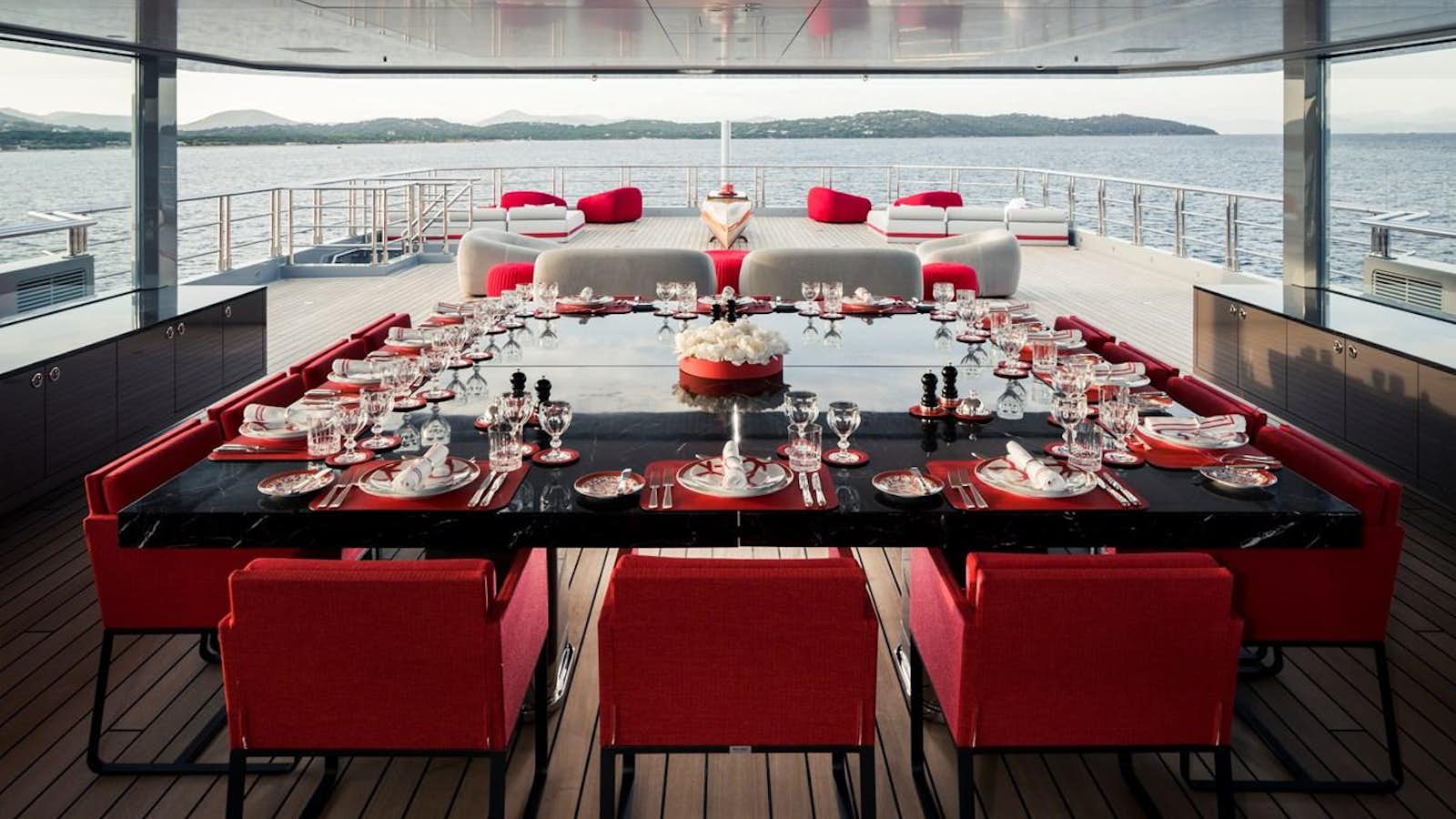 a table with red chairs and red chairs aboard BOLD Yacht for Sale