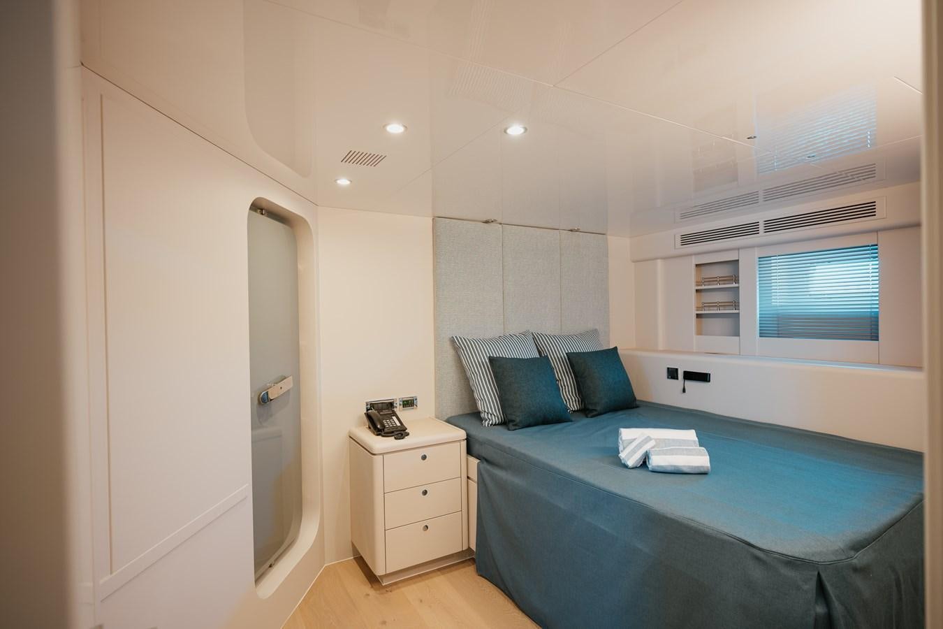 a bedroom with a bed and a desk aboard SEAL Yacht for Sale