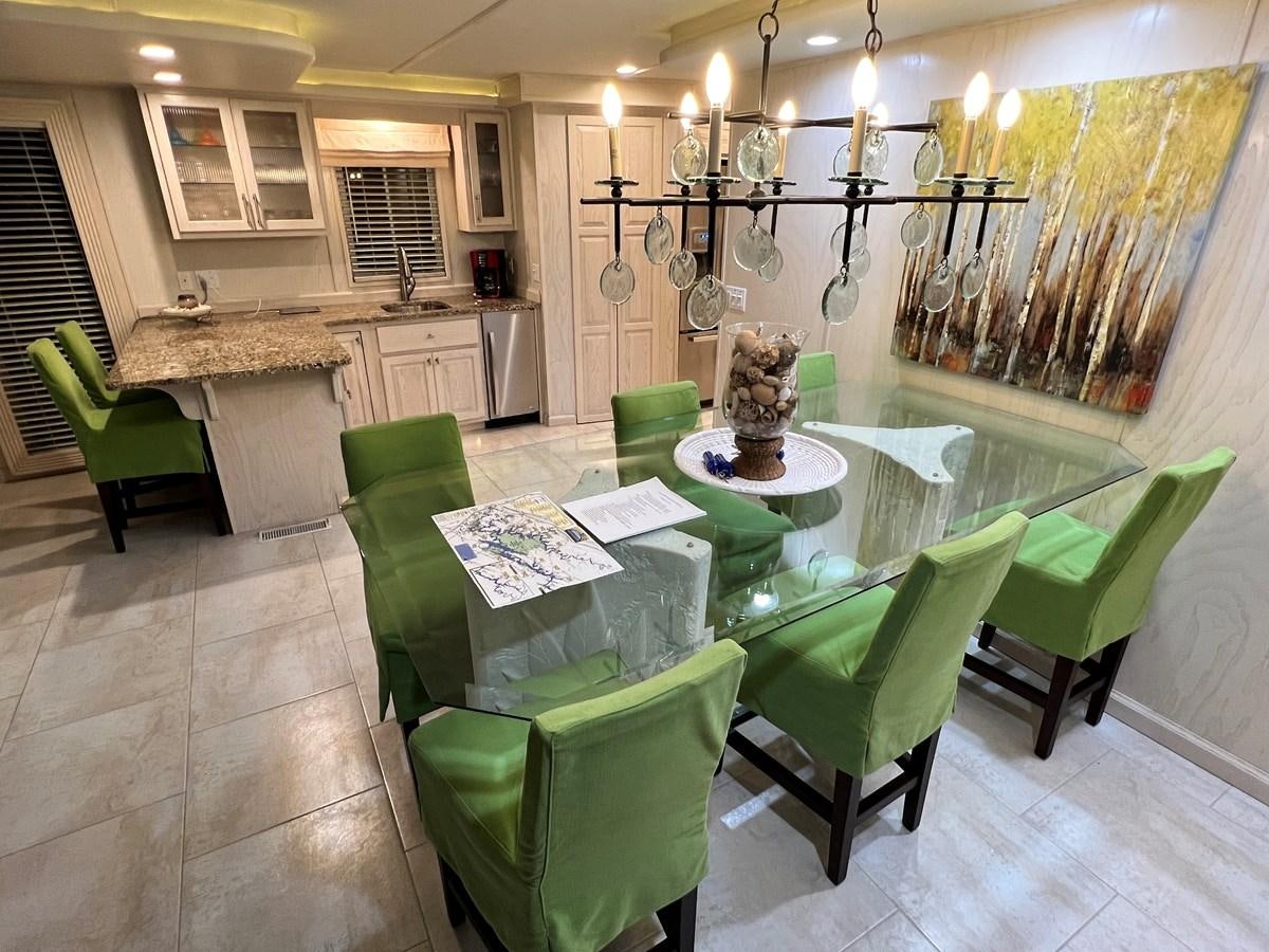 a kitchen with green chairs aboard 2010/1995 STARDUST 20 X 95WB NLST Yacht for Sale