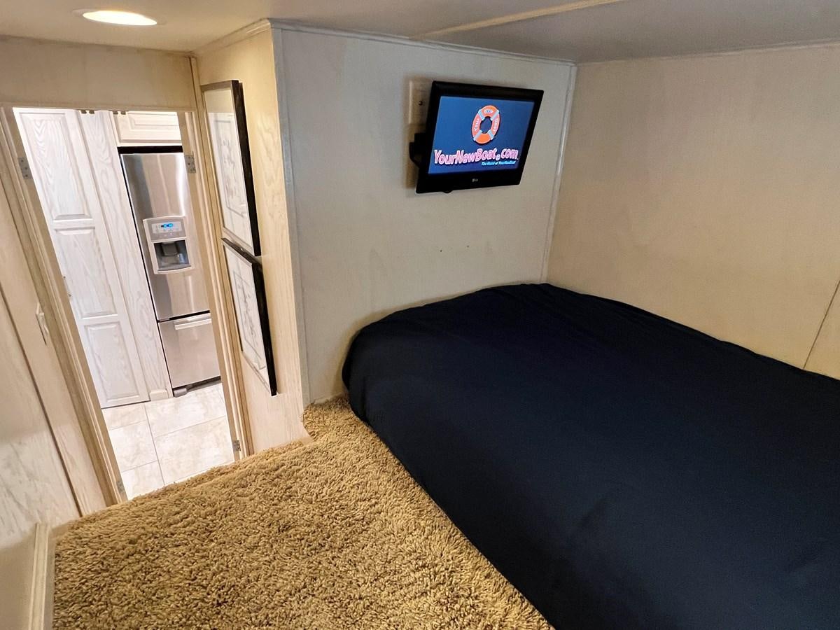 a bedroom with a bed and a tv on the wall aboard 2010/1995 STARDUST 20 X 95WB NLST Yacht for Sale