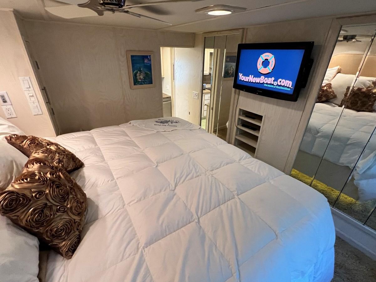 a bed with a television on the wall aboard 2010/1995 STARDUST 20 X 95WB NLST Yacht for Sale