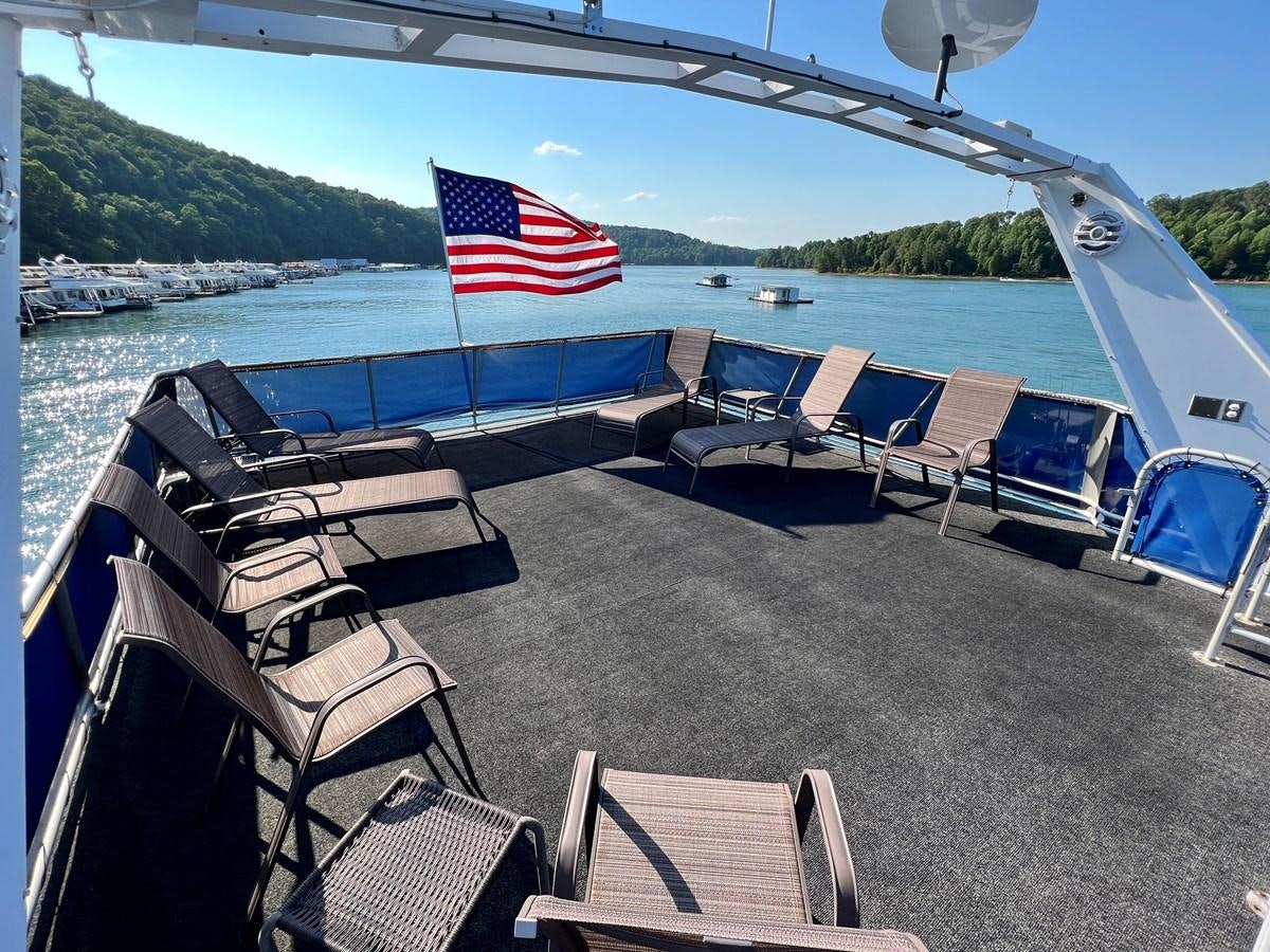 a boat with chairs and a flag on it aboard 2010/1995 STARDUST 20 X 95WB NLST Yacht for Sale