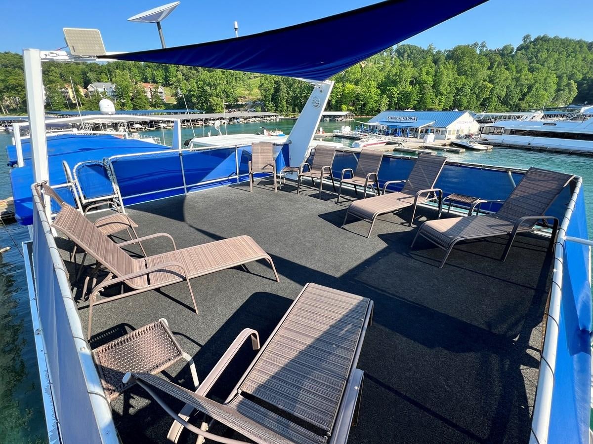 a deck with chairs and tables on it aboard 2010/1995 STARDUST 20 X 95WB NLST Yacht for Sale