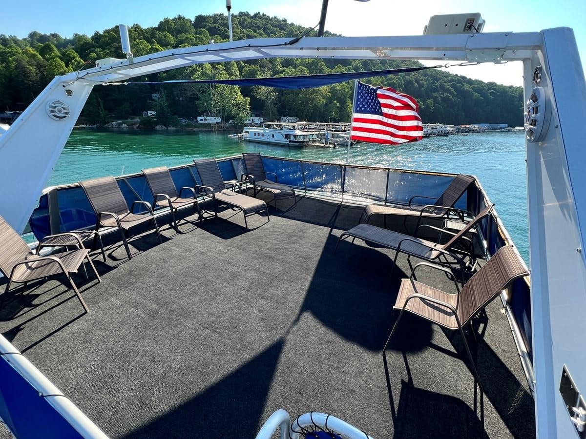a deck with chairs and a flag on it aboard 2010/1995 STARDUST 20 X 95WB NLST Yacht for Sale