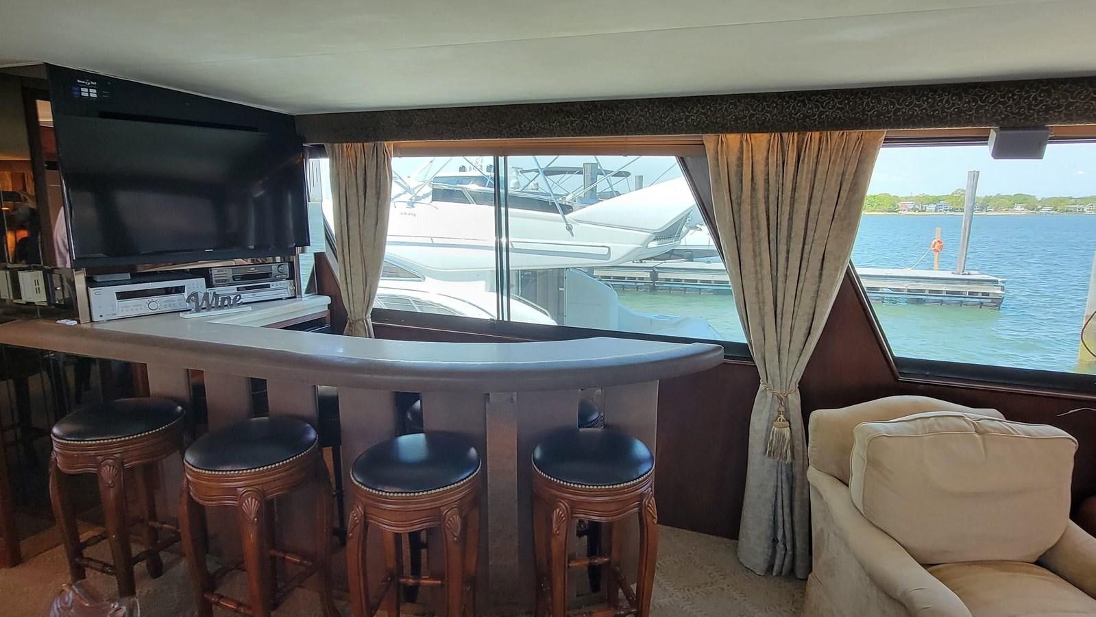 a room with stools and a television and a window aboard LADY PATRICIA Yacht for Sale