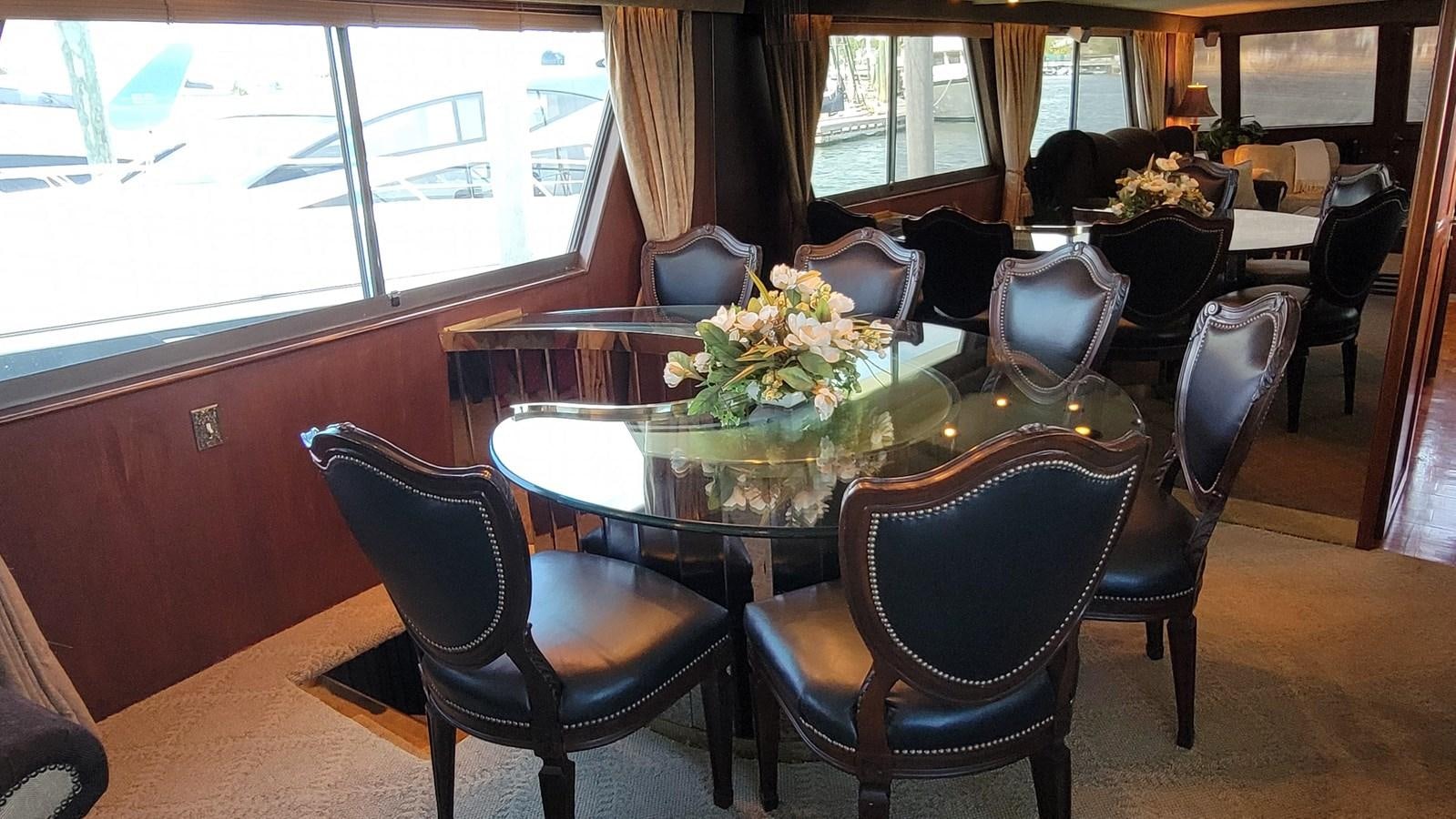 a dining room table with chairs and a large window aboard LADY PATRICIA Yacht for Sale