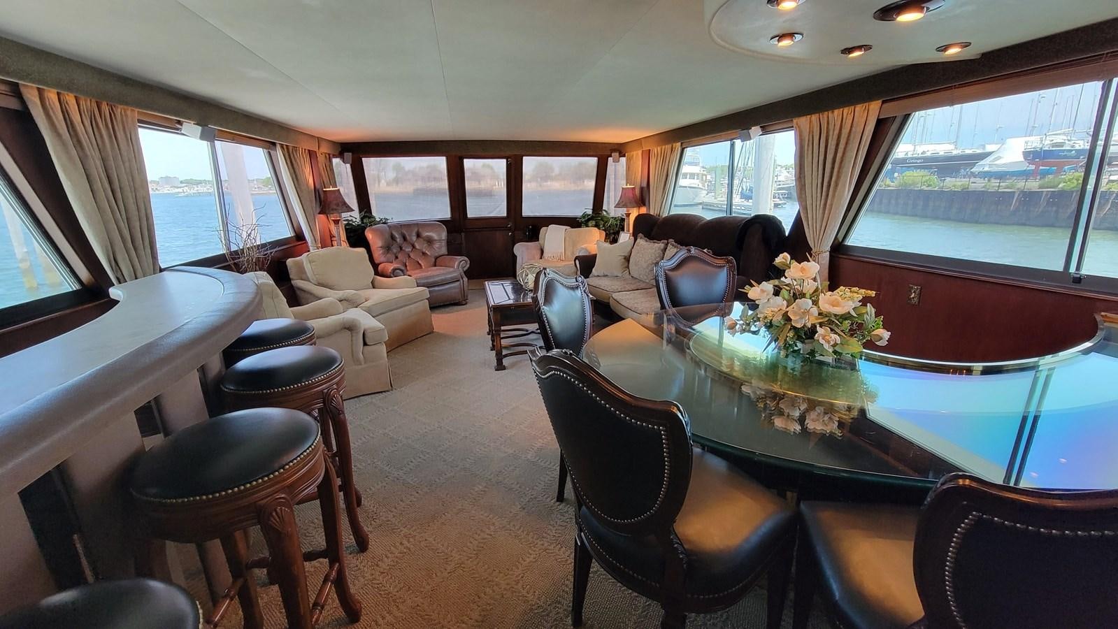 a living room with a table chairs and a large window aboard LADY PATRICIA Yacht for Sale