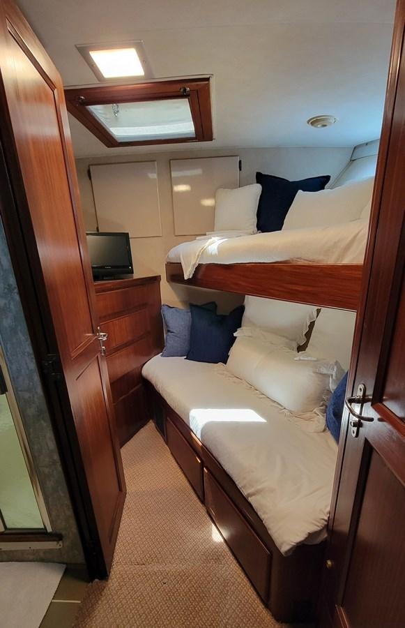 a room with a bed and a television aboard LADY PATRICIA Yacht for Sale