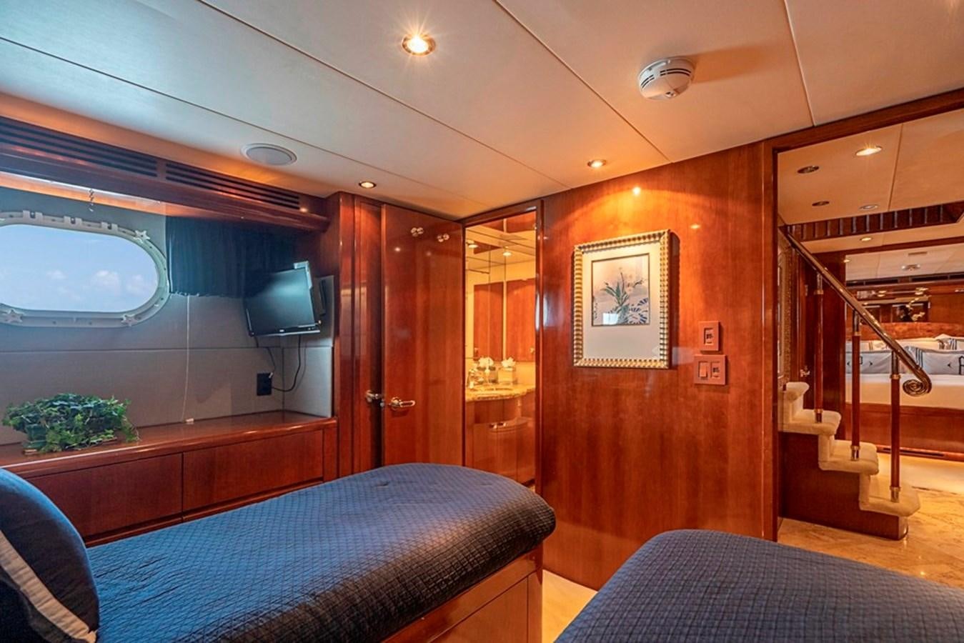 a bedroom with a bed and a television aboard PURA VIDA Yacht for Sale