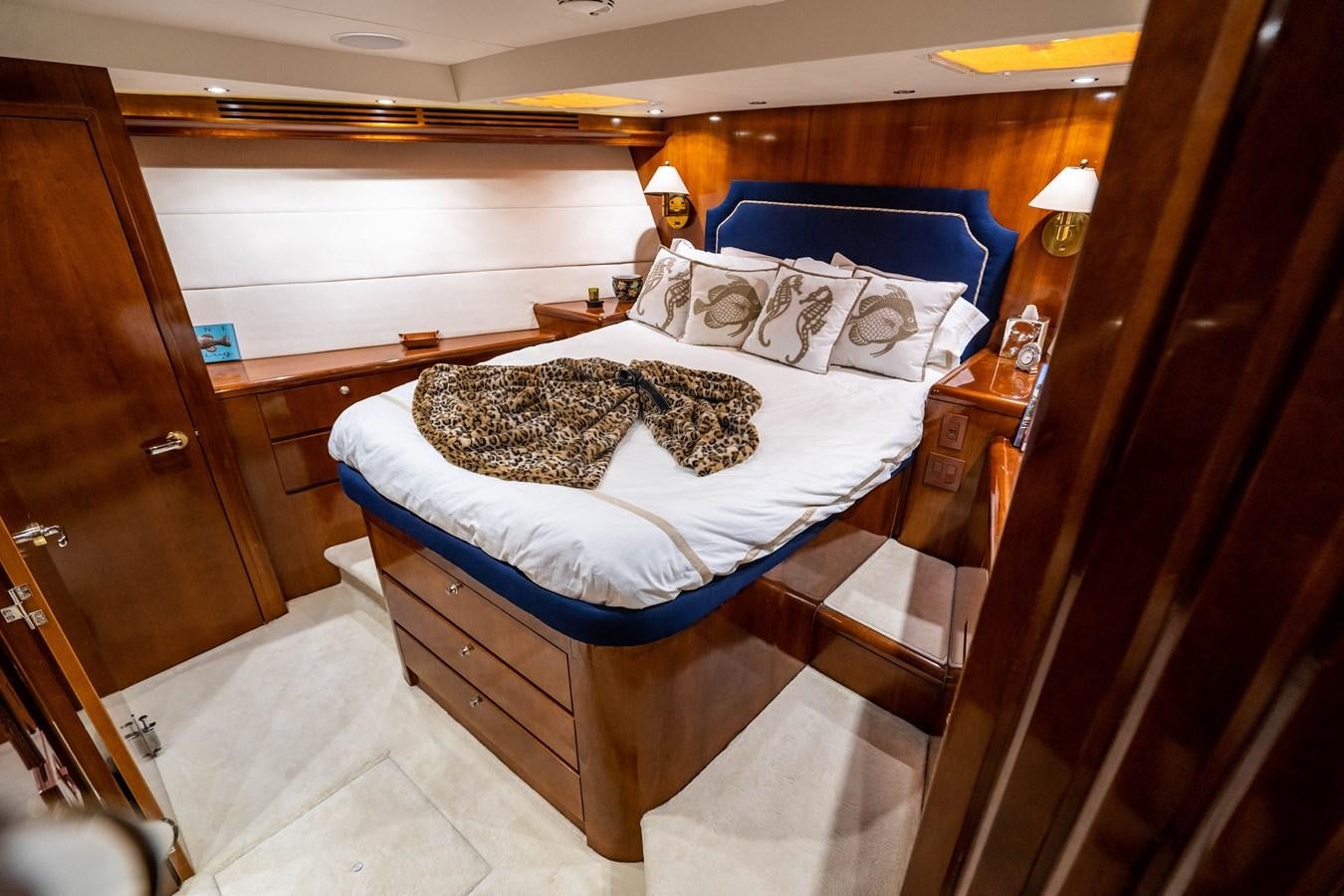 a bedroom with a bed and a wood door aboard PURA VIDA Yacht for Sale