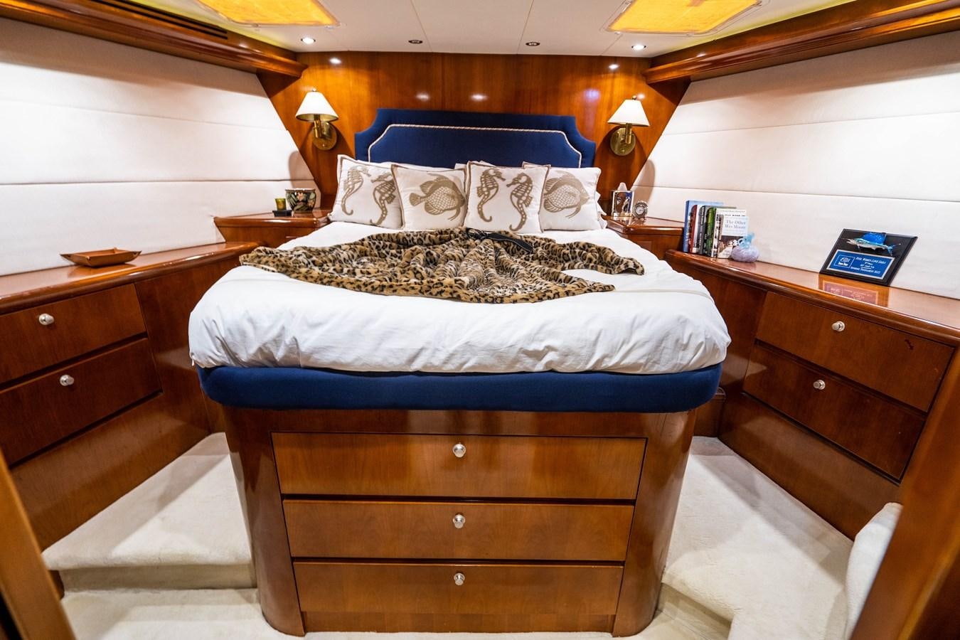 a bedroom with a bed and a desk aboard PURA VIDA Yacht for Sale