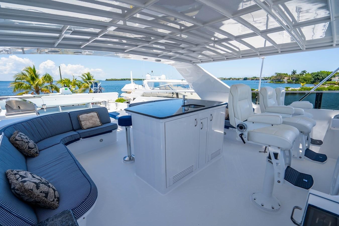 a large white lounge chair on a deck with a large white table and a large rock on the aboard PURA VIDA Yacht for Sale
