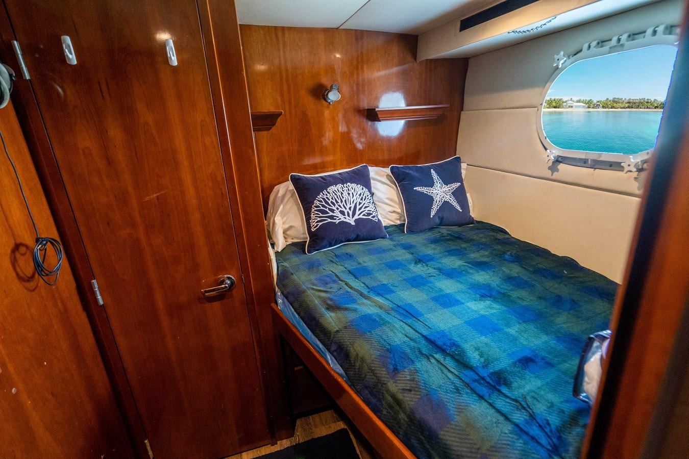 a bed with blue sheets aboard PURA VIDA Yacht for Sale