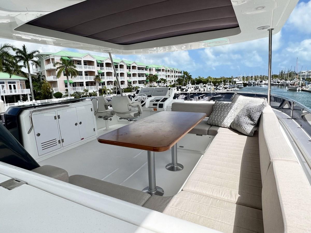 a deck with a table and chairs on it aboard SIRENA 64 FLYBRIDGE Yacht for Sale