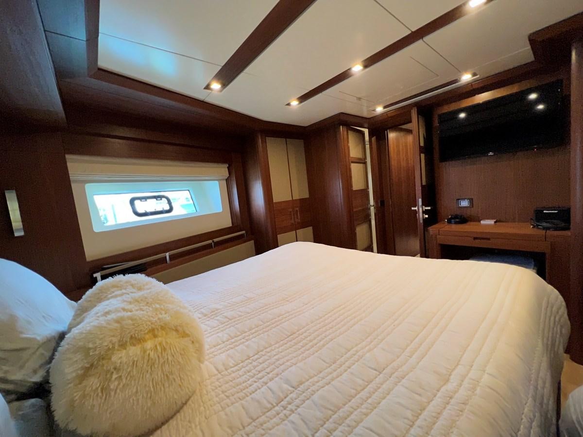 a bed with a television on the wall aboard SIRENA 64 FLYBRIDGE Yacht for Sale