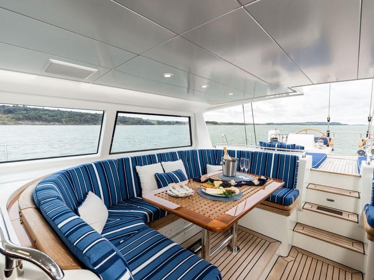 a room with a table and chairs aboard CHARLATAN Yacht for Sale
