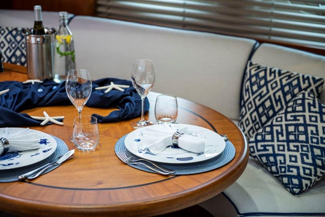 a table with plates and glasses on it aboard CHARLATAN Yacht for Sale