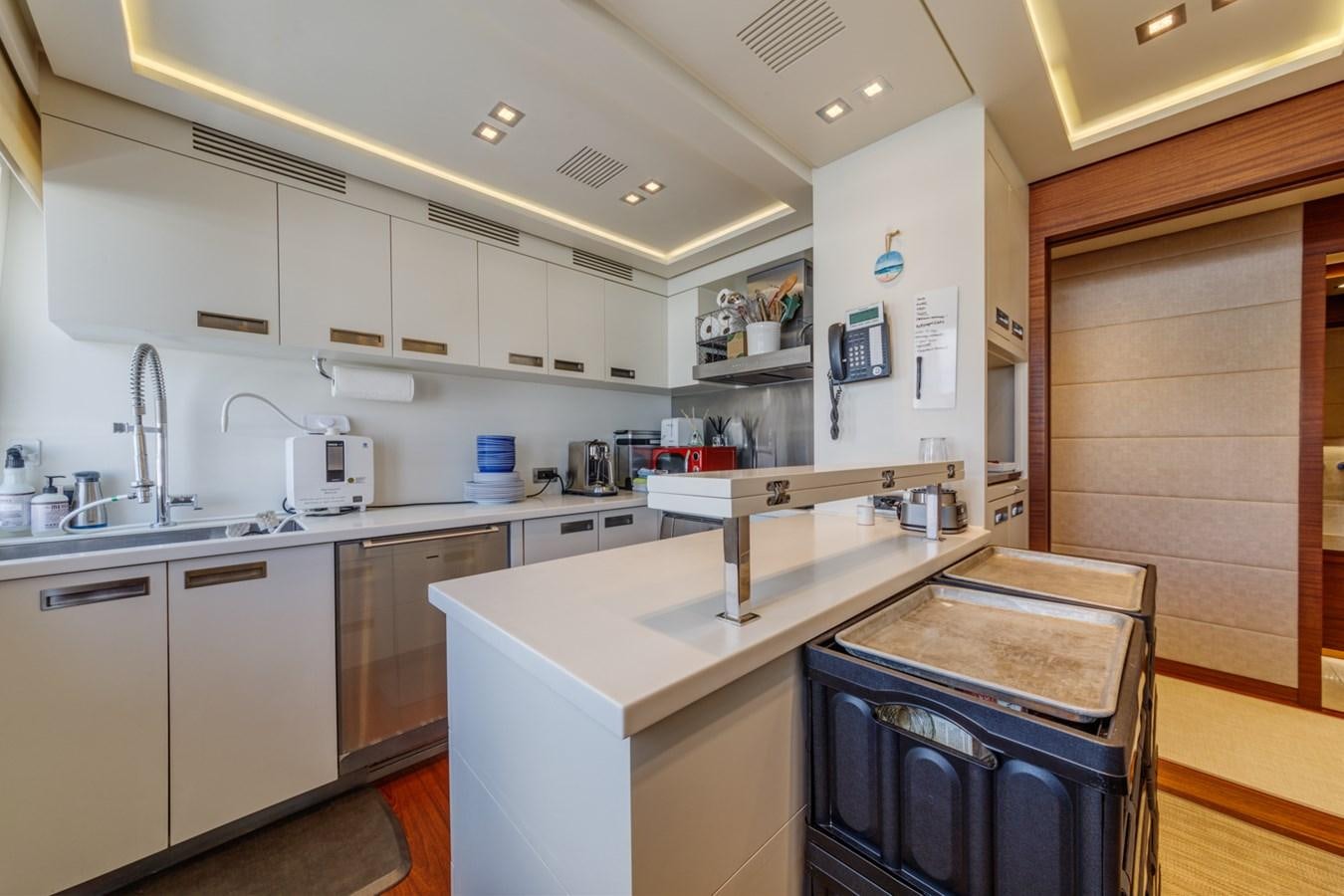 a kitchen with white cabinets aboard PRIMA MEA Yacht for Sale