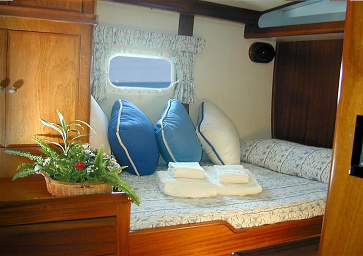 a bed with a chair and a plant on it aboard AURASTEL Yacht for Sale