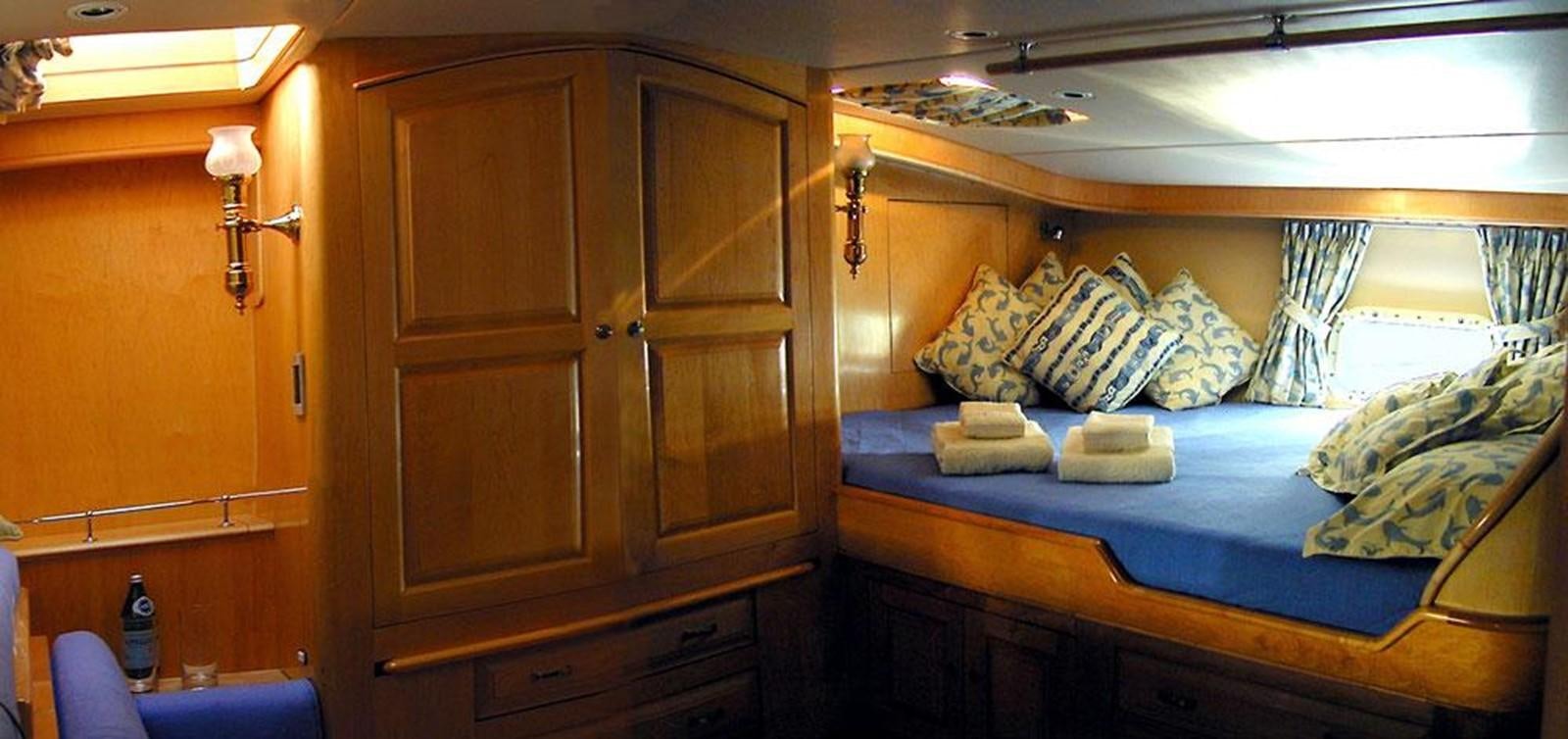 a bed with a wooden cabinet aboard AURASTEL Yacht for Sale