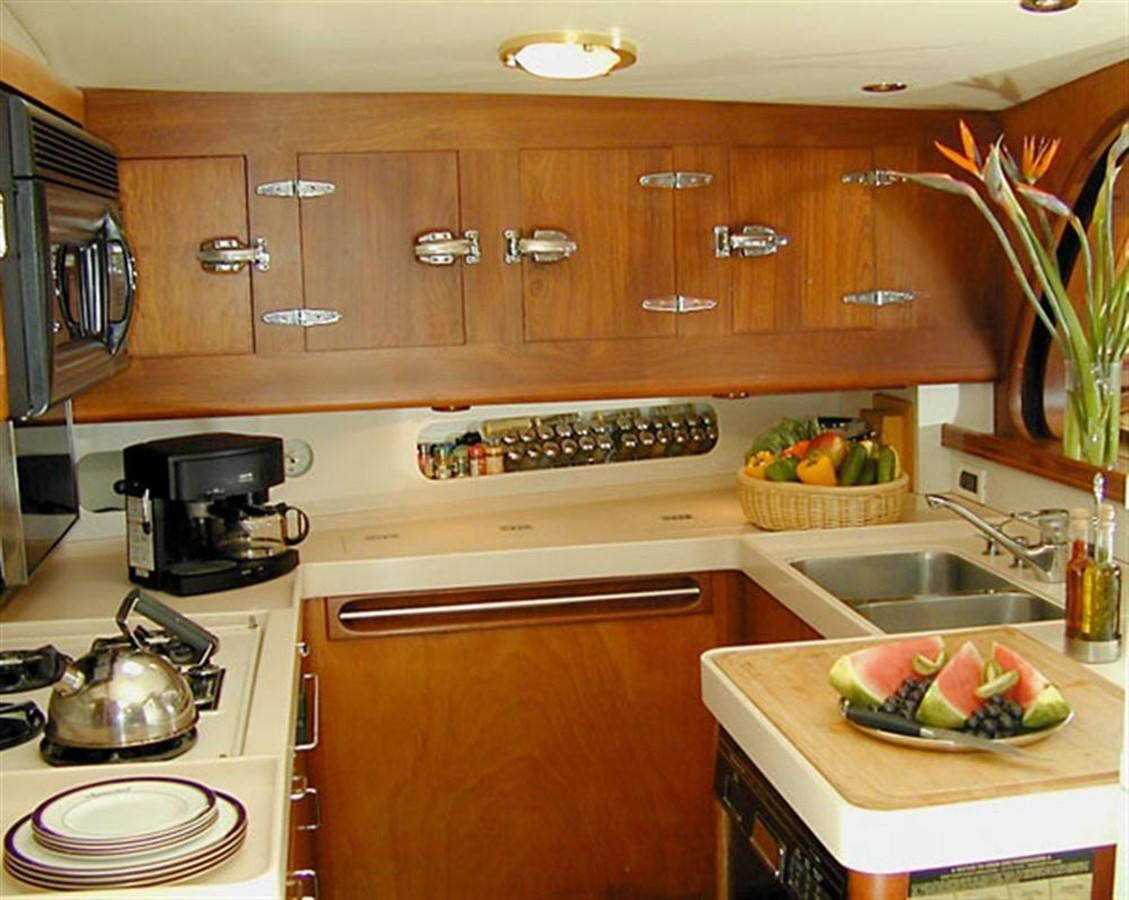 a kitchen with wooden cabinets aboard AURASTEL Yacht for Sale