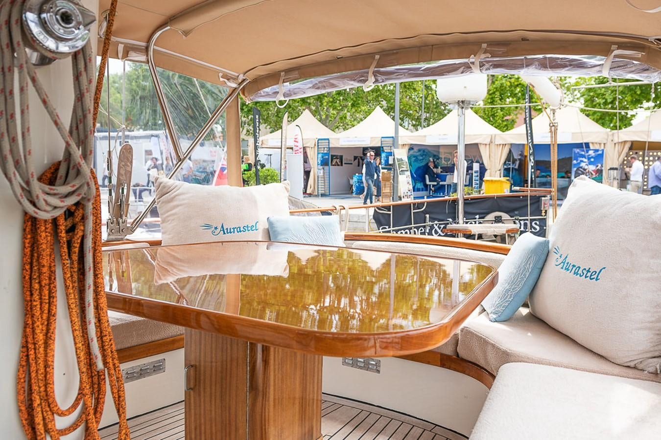 a boat with a table and chairs aboard AURASTEL Yacht for Sale
