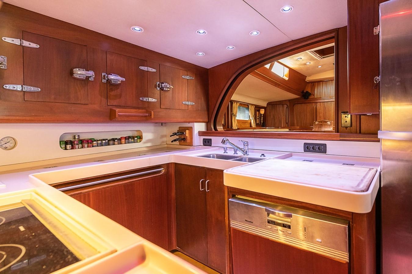 a kitchen with wooden cabinets aboard AURASTEL Yacht for Sale