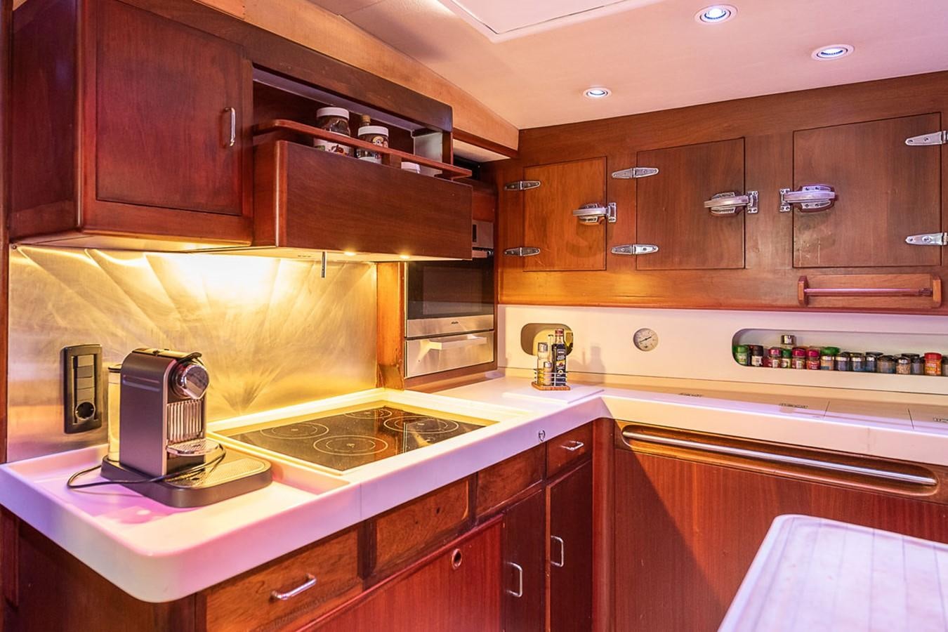 a kitchen with wooden cabinets aboard AURASTEL Yacht for Sale