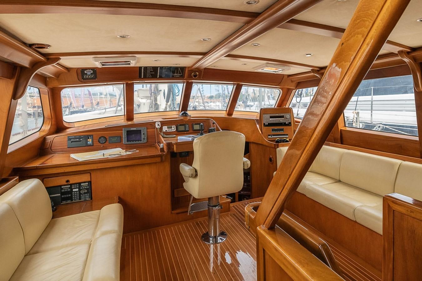 a train with a seat and a table and chairs aboard AURASTEL Yacht for Sale