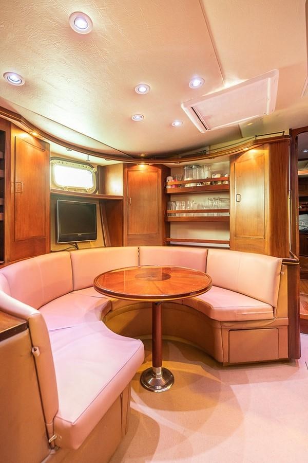 a living room with a table and chairs aboard AURASTEL Yacht for Sale