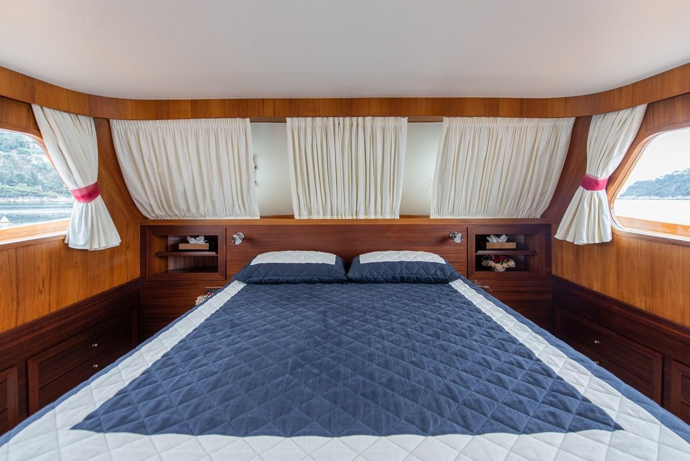 a bed with a blue comforter aboard SANS SOUCI Yacht for Sale
